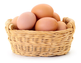 Brown chicken eggs in a small wicker basket isolated on white background