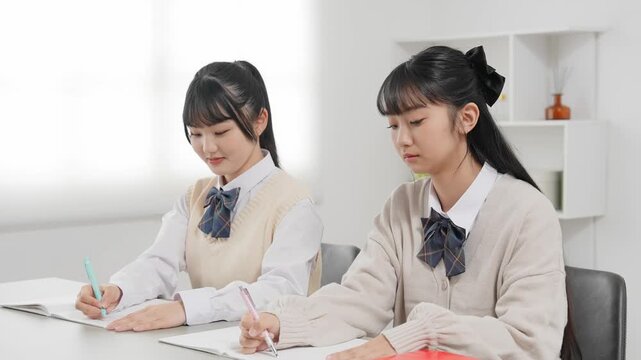 部屋で勉強する二人の女子学生