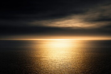 Obraz premium Minimal seascape golden hour horizon background Dramatic golden sunset over calm ocean horizon with dark storm clouds and glowing light
