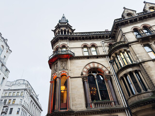 Naklejka premium Historic Manchester building with ornate towers and tall windows on a city street