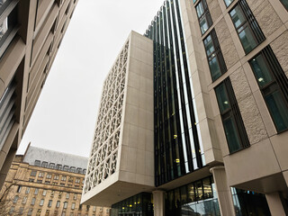 Naklejka premium Modern glass and concrete office buildings rise along a street in Manchester UK skyline
