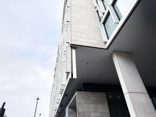 Naklejka premium Modern London building exterior with concrete columns and overhangs, showcasing architectural urban facade