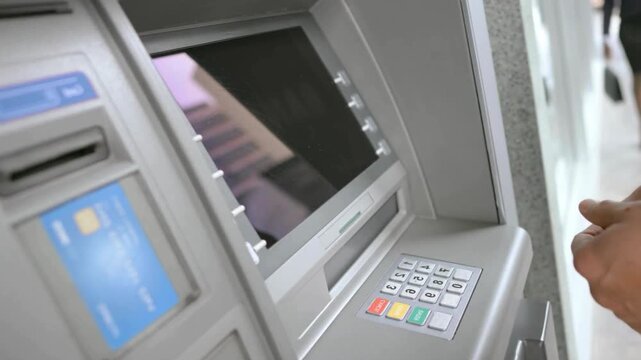 Close up of hand typing pin code on atm keypad using card for financial transaction online banking and cash withdrawal concept