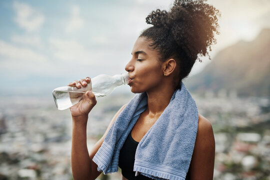 Fitness, black woman and drinking water outdoor for health, wellness and electrolytes on break. Tired runner, person and bottle for hydration, refresh and detox with liquid after workout with sweat