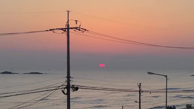 노을지는 하늘과 바다 배경의 전봇대