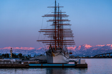 夕方の海王丸パークから新湊大橋と海王丸を前景にピンク色染まる立山連峰アーベンロート