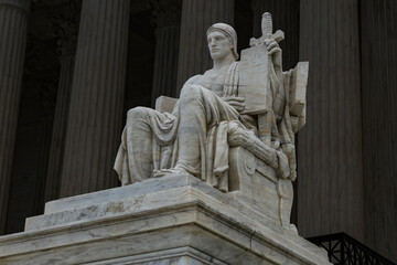 Fototapeta premium Contemplation of Justice and Authority of Law symbolism. Supreme court columns symmetry neoclassical architecture. Law constitution judicial power governance. Marble sculpture legal background.