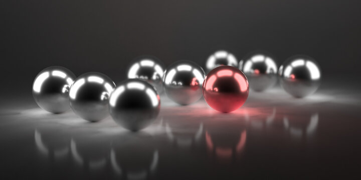 Reflective silver spheres with a single red chrome ball on glossy surface for abstract minimal background design.3d render