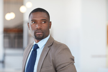 Fototapeta premium Ambitious, employee and man in office, thinking and planning for financial growth, ideas or serious. Business, investment banker and black person with decision for funding opportunity and reflection