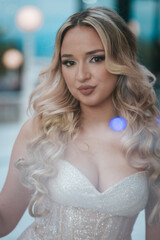 Blonde Teen in Silver Prom Dress, Playful Pose, Urban Background © stivog