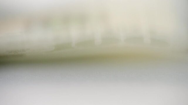 Close up shaking dollar bill, macro focus on textured security paper, soft blur and subtle vibration, shallow depth highlighting printed design and serial detail, studio lighting