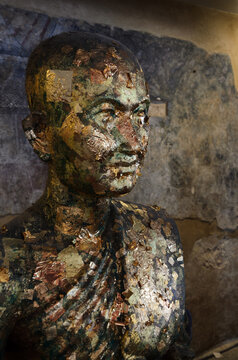 Close-up of Buddhist monk statue with gold leaf