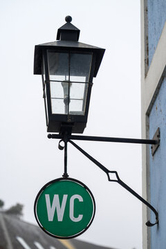 Laterne und WC-Hinweisschild an Geb&auml;ude