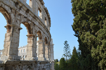 Obraz premium Ancient Roman amphitheater arches against blue sky