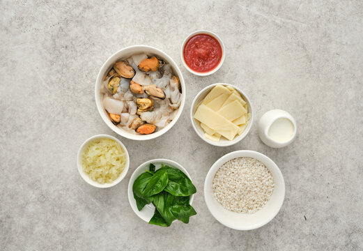 Preparation of seafood risotto with various ingredients in a kitchen setting at mealtime