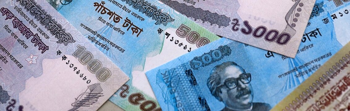 Bangladeshi taka money bills pile on table. Bangladesh banknotes of BDT currency close up.