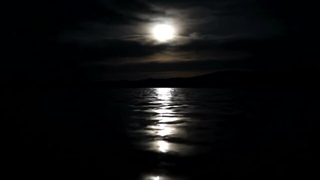 Moonlight reflects on water under cloudy night sky  (37)