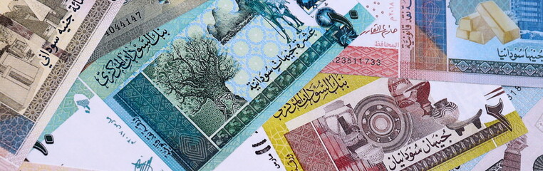 Sudanese pound money bills pile on table. Sudan banknotes of SDG currency close up.