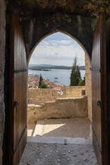 Obraz premium View through medieval St. Michael's Fortress entrance gate, overlooking city and Krka River, Sibenik, Croatia