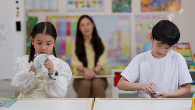 Asian Children Learning to Tell Time with Clock Toys in Classroom