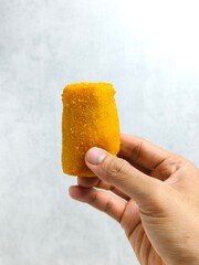 Hand Holding Risol Mayo &ndash; Crispy Indonesian Fried Roll with Mayonnaise, Smoked Beef and Boiled Egg