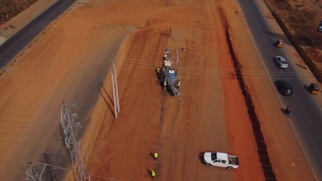Aerial of workers using heavy equipment being used in roadside construction in FCT, Abuja, Nigeria