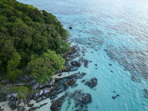 Aerial view of Tanjung Gelam Beach where the lush green forest meets the turquoise sea, Karimunjawa, Central Java, Indonesia.