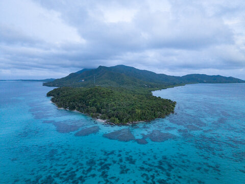Aerial view of lush green island surrounded by turquoise waters, a serene tropical paradise, Karimunjawa, Central Java, Indonesia.