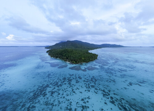 Aerial view of the lush green island surrounded by turquoise waters, Tanjung Gelam Beach, Karimunjawa, Central Java, Indonesia.