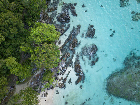 Aerial view of the rugged Tanjung Gelam Beach where emerald foliage meets the turquoise sea, Karimunjawa, Central Java, Indonesia.