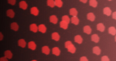 Abstract red bokeh light pattern with soft glowing dots on dark background