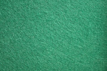 A detailed close-up texture of a green felt fabric surface commonly used for billiard or poker tables. Concept: Concept of textile background. © Helga P-A.
