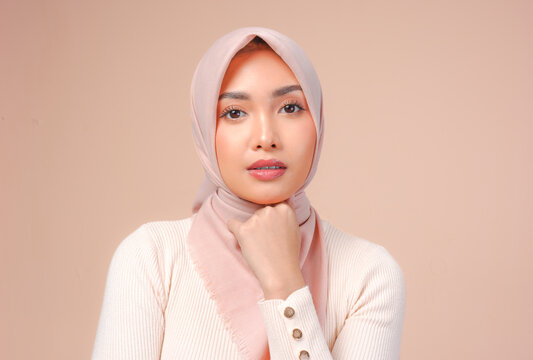 Chic young Asian Muslim woman wearing veil hijab with make up posing and looking to the camera.