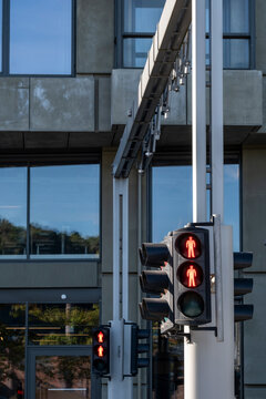 Daylight city intersection with urban street signal and modern building facade windows showing traffic control system and contemporary architecture detail with clean geometry