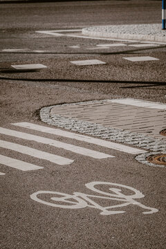 Street level bicycle lane on urban asphalt pavement with marking and crosswalk texture in daylight showing city cycling mobility infrastructure and clean surface detail