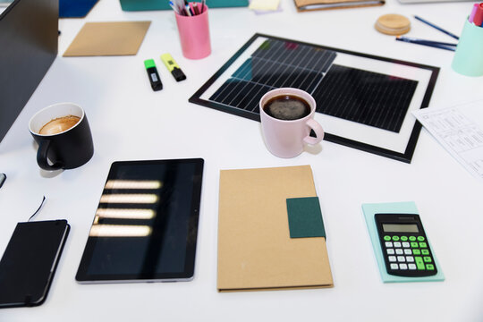Office meeting table with documents, solar panel and business workspace