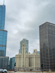 City skyline view showing historic building with clock tower and modern skyscrapers under cloudy sky in Chicago during daytime