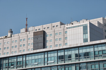 Fototapeta premium Modern building exterior facade with windows under clear sky.