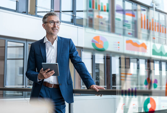 Businessman using tablet in modern office with digital data graphics