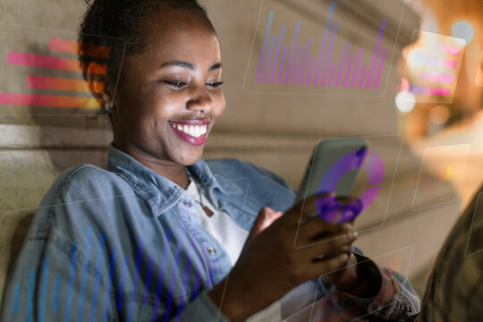 Smiling person using smartphone with digital data graphics at night