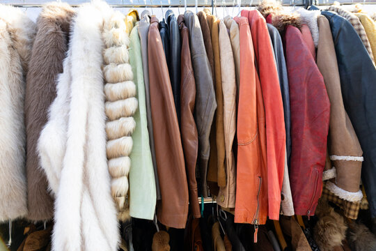 Vintage faux fur and leather coats on rack at flea market