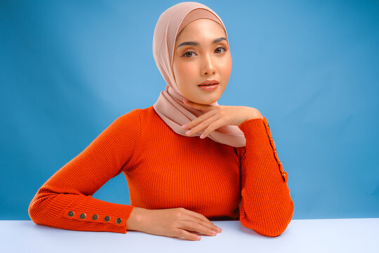 Attractive young Asian Muslim woman wearing veil hijab with make up is posing and smiling.