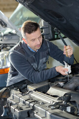 automotive specialist adjusting an engine in his garage