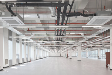 Large empty open-plan floor with exposed ceiling and columns, modern building interior.
