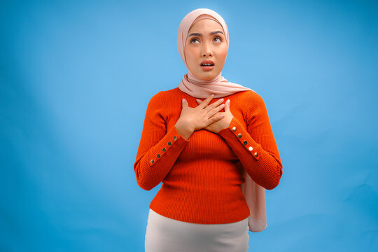 Young Asian Muslim woman wearing hijab is trying to be peaceful and keeping cool.