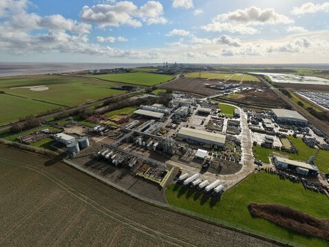 Aerial view of BOC Gases industrial complex, a symphony of steel and concrete amidst the verdant landscape, under a vast, cloud-strewn sky, Grimsby, United Kingdom.