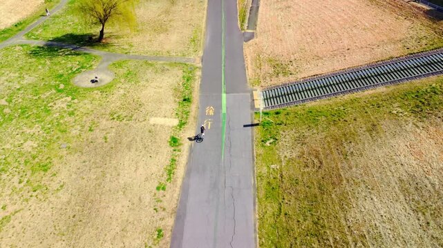 土手沿いを走る自転車を空撮　4K