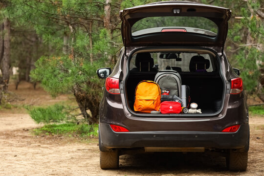 Emergency backpacks with necessities in open car trunk outdoors