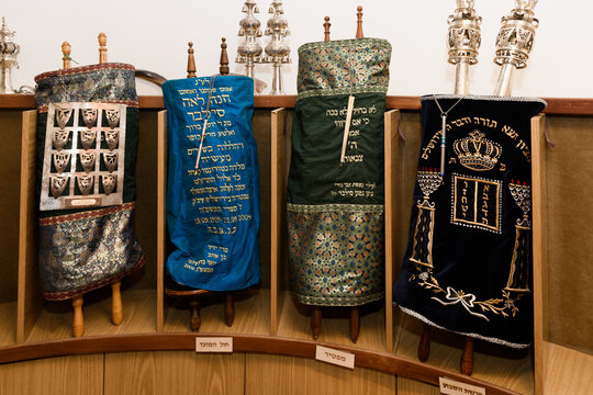 Torah scrolls wrapped in decorative cloth coverings and housed in the holy ark in the sanctuary of a synagogue in Israel.