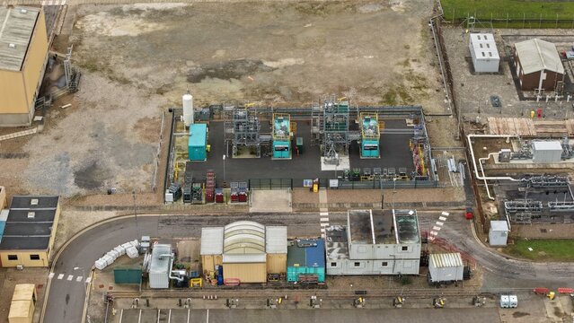 Aerial view of industrial architecture, a symphony of steel and concrete meeting the muted tones of the Brigg Renewable Energy Plant, Brigg, United Kingdom.